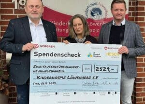 Spendenübergabe am Vereinsheim des Kinderhospiz Löwenherz e.V. in Syke bei Bremen. Werner Brandis, Axxeron Hesch Electronics (li.) und Christian Bolda, Standortleiter Buschjost (re.) übergeben die Spende an U. Ströhmann, ehrenamtliche Mitarbeiterin bei Löwenherz.